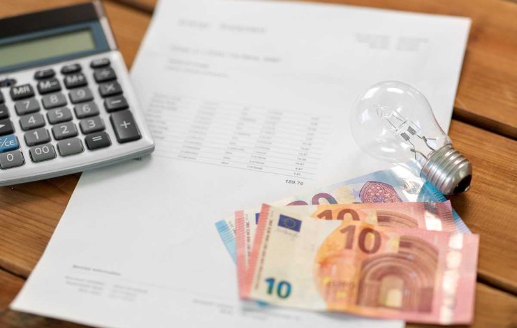 Calcolatrice, bollette, euro e lampadina