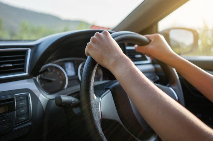 mani di donna su volante alla guida