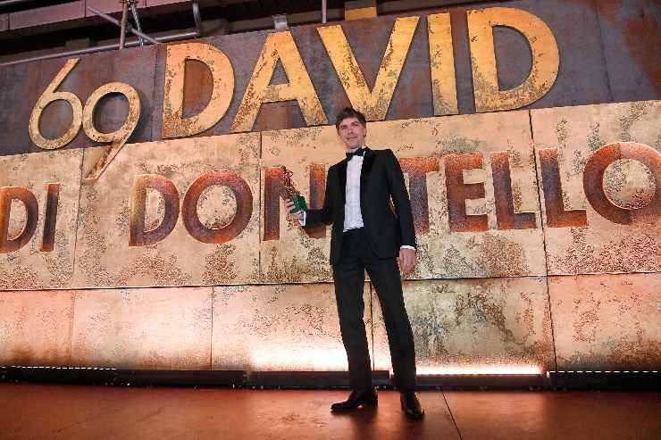 attore davanti cartello david di donatello