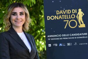 donna sorride davanti il cartellone dei david